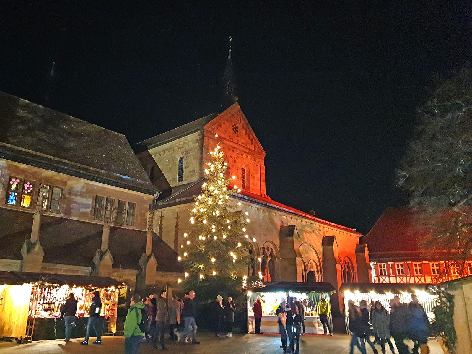 Stimmungsvoller Blick auf die Klosterkirche mit Weihnachtsbaum und Weihnachtsmarktstand